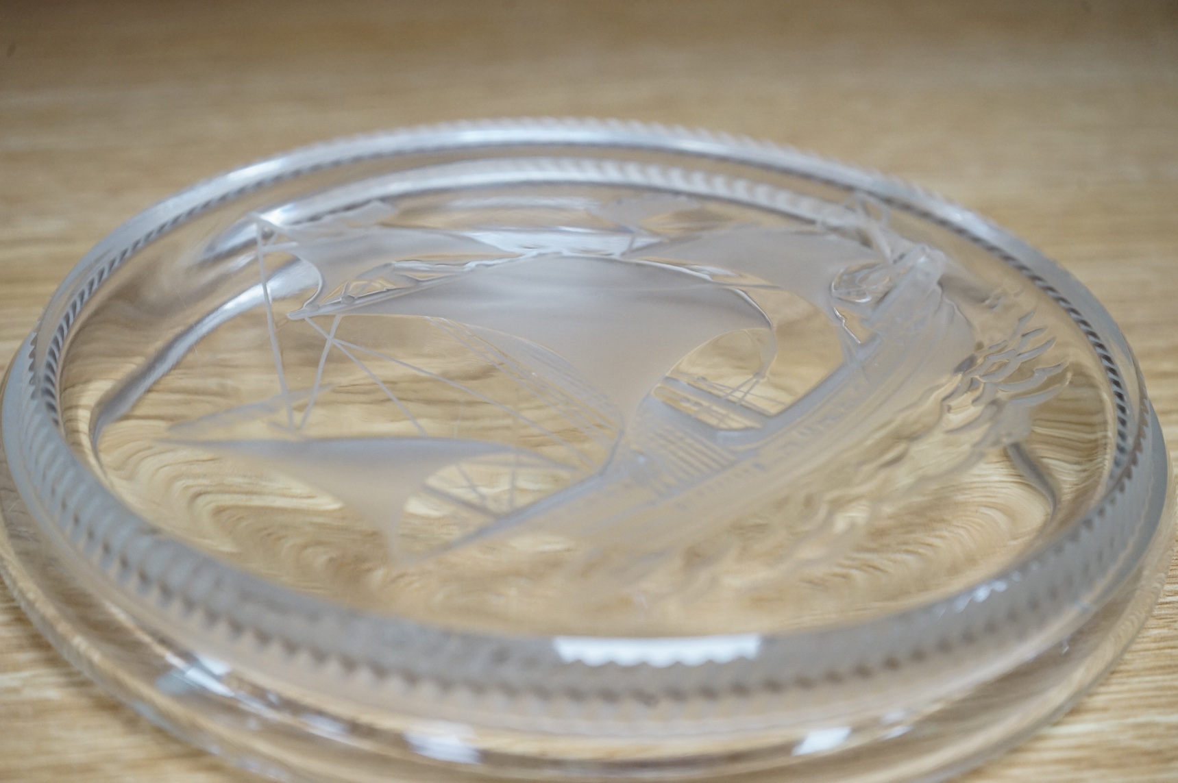 A modern Lalique ashtray decorated with a ship, signed to the base, 17cm in diameter. Condition - good